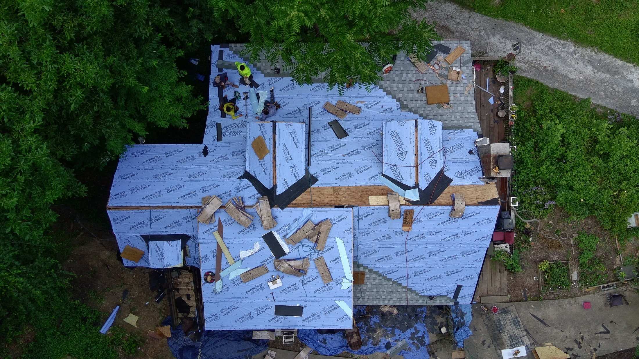 Iron Ridge crew working on a roof with tarps protecting the ground below